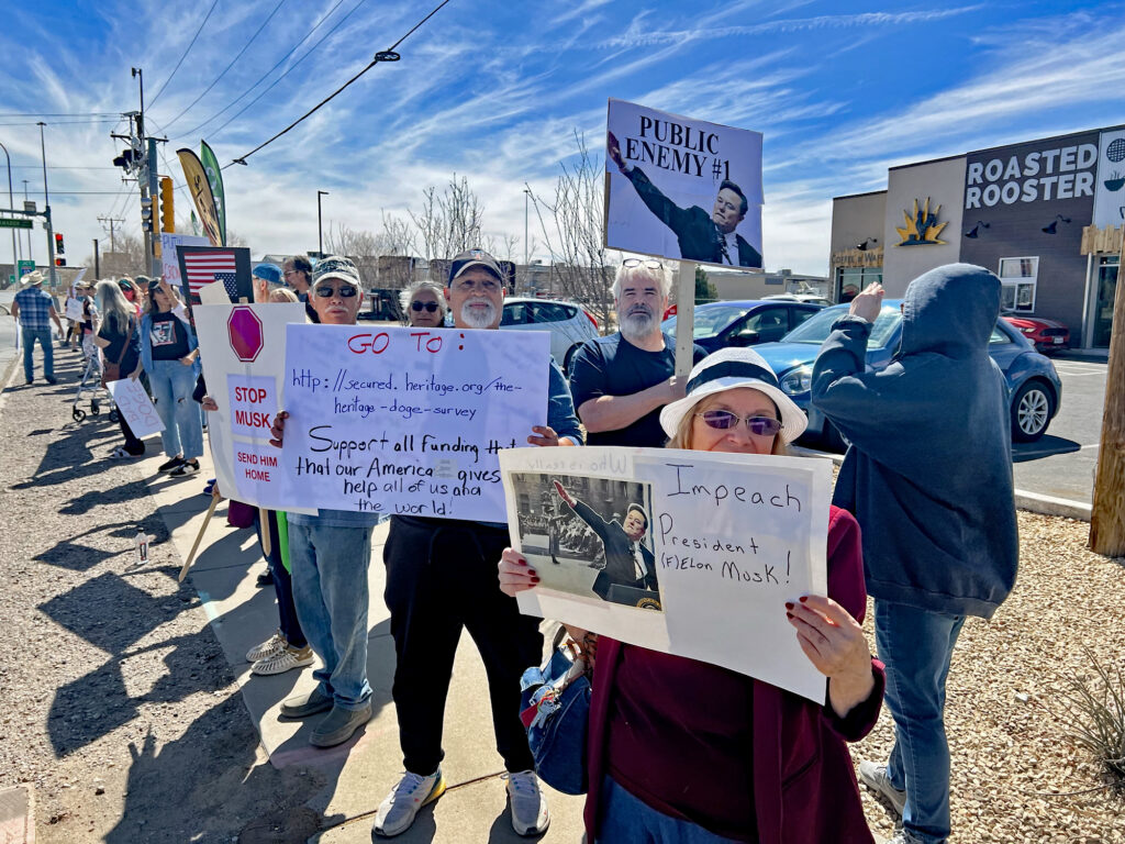 Two of the homemade signs brought by protesters included a photo of Elon Musk making the Nazi salute at President Donald Trump’s inauguration in January.