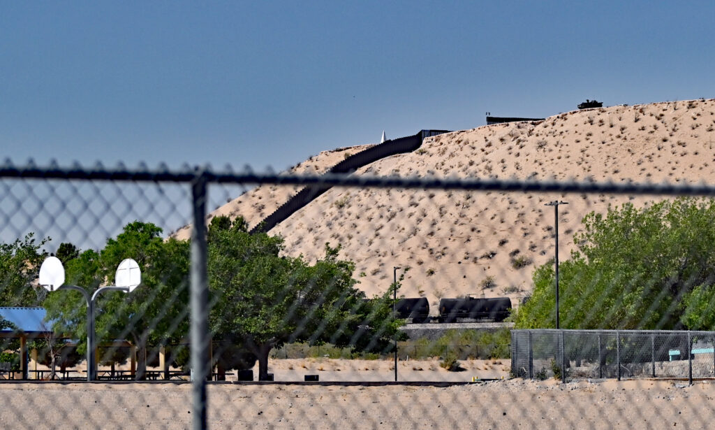 A U.S. Army Stryker is parked on a mesa next to the border wall. It's shown here from the playground at Sunland Park Elementary School, which is just a few hundred yards away.