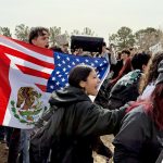 Teens demonstrate outside the fence surrounding Mayfield High School.