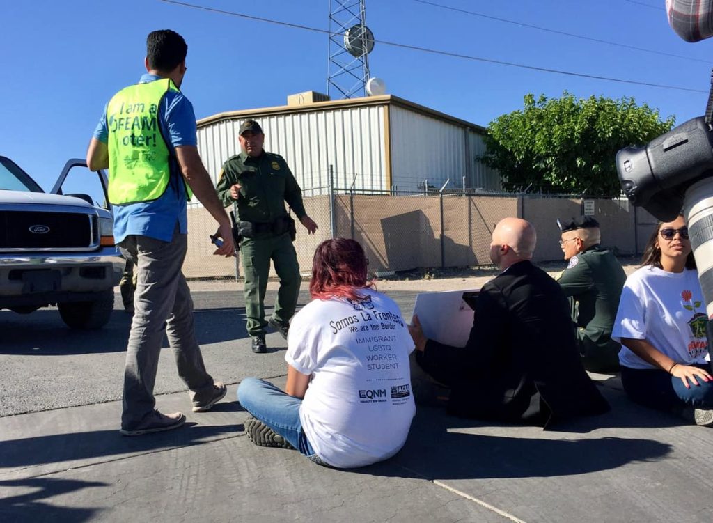 A Border Patrol agent approaches my friend Bill McCamley (the guy in the black suit) and others who blocked his exit during the 2017 protest. The agent revved his engine at the protesters before getting out of his vehicle to speak with them. (Photo by Heath Haussamen)