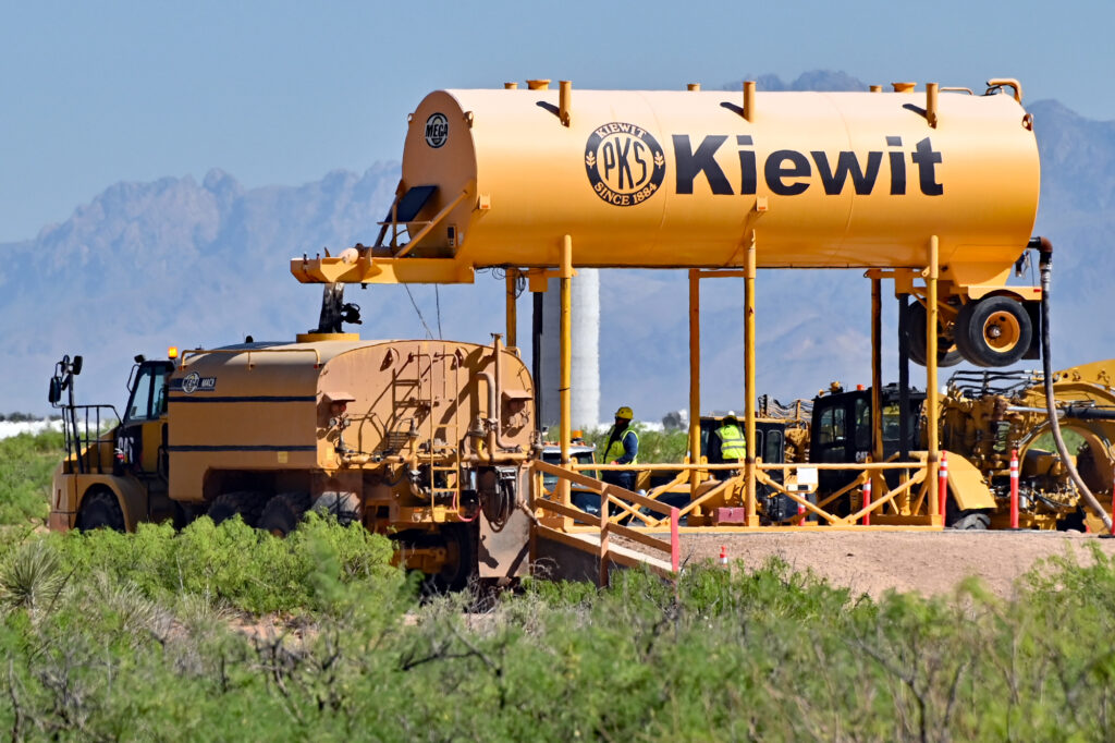 A worker refills a water truck at the construction site for one of two gas-fired power plants Project Jupiter's developers plan to build.