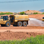 A truck sprays water last week on leveled earth at the construction site of one of two microgrids planned to power Project Jupiter's data centers in Santa Teresa.
